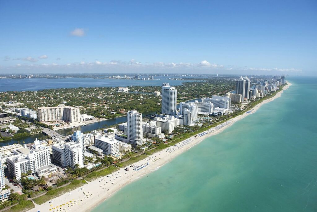 Aerial view of Miami Beach coastline and nearby buildings.